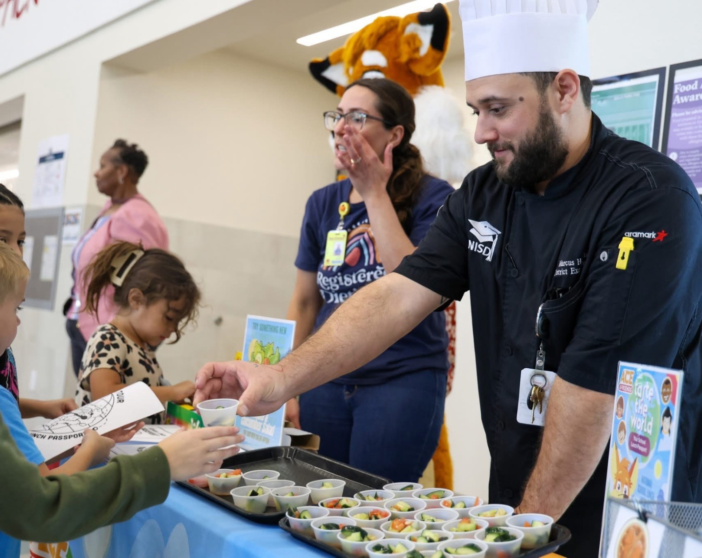 A culinarian serves food to students. 